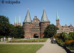 Das Holstentor in Lbeck, im Hintergrund sind die Salzspeicher zu sehen  -   Fr eine grere Darstellung bitte auf das Bild klicken.